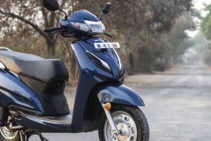 honda activa scooter in black and blue color on road near some trees