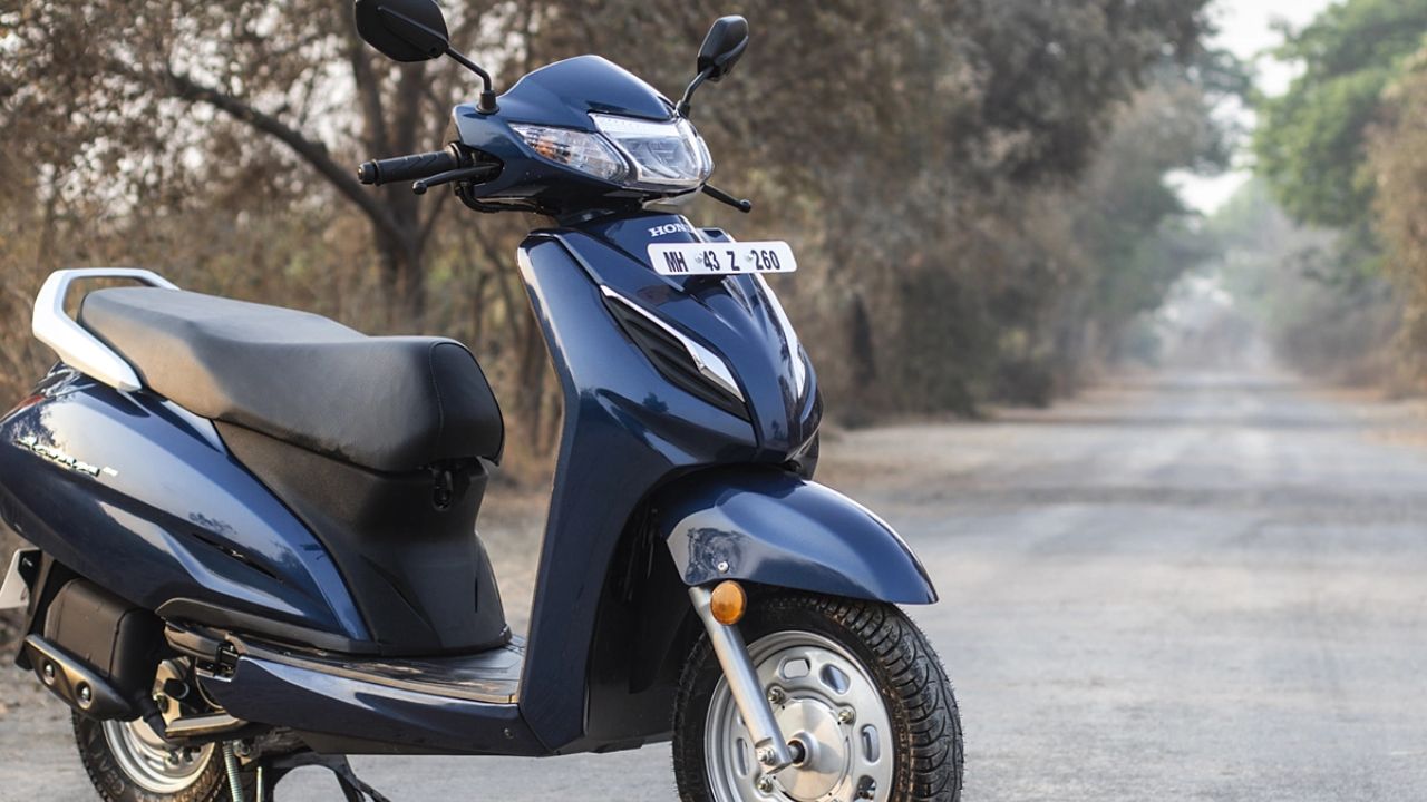 honda activa scooter in black and blue color on road near some trees