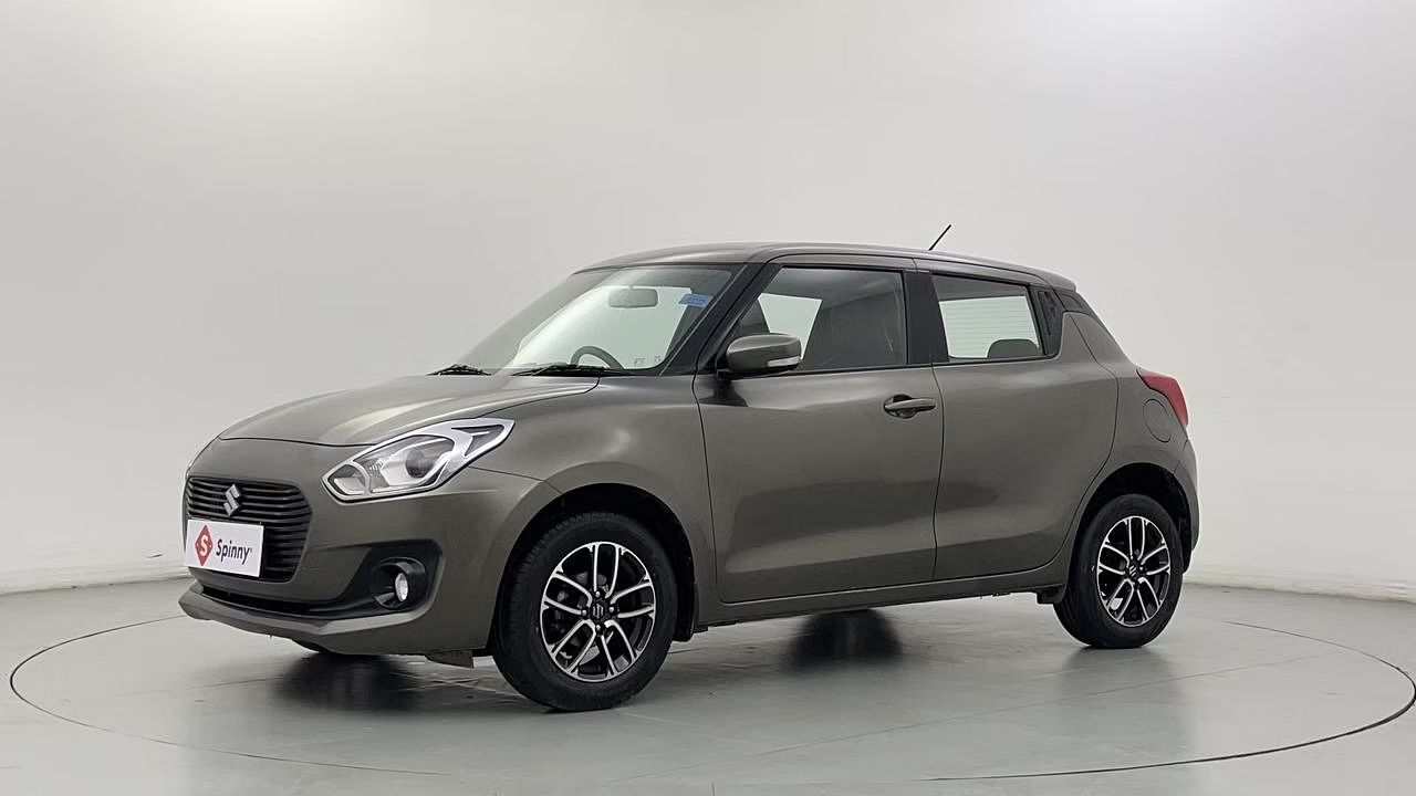 Maruti Suzuki Swift in dark grey color in light grey color plain background