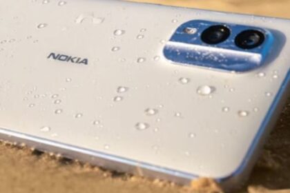 Nokia C12 Pro in beige color on sand and sparking some water on phone