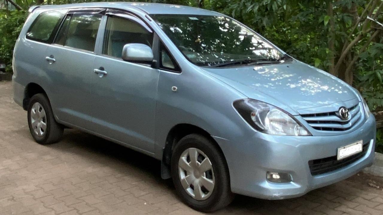 Toyota Innova in light blue color on road near some trees