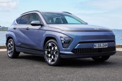 Here is image of Purple colour Hyundai Kona Electric Car Which is placed besides the Sea