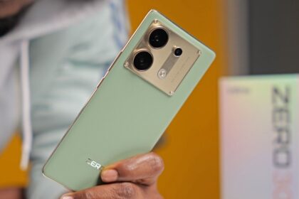 Infinix Zero 30 5G in mint green and gold color in a man hand with box near table
