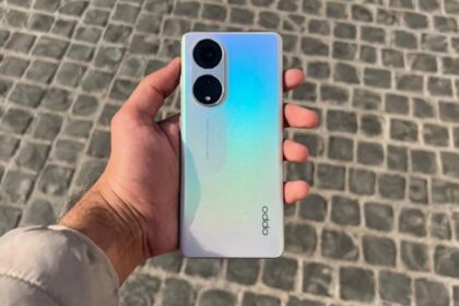 Oppo Reno 8T in hand in light blue and gold color near road
