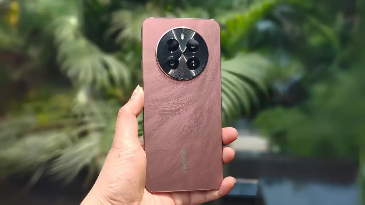 Realme P1 5G in phoenix red color in hand infront of some trees