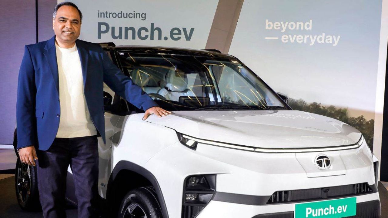 Here is Image of A man Standing with TATA Punch EV which is in white colour