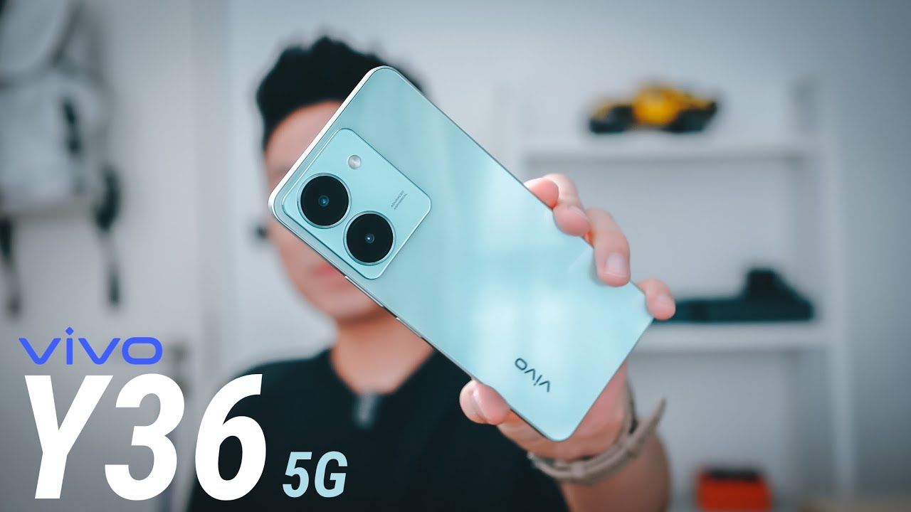 a man holding Vivo Y36 in mint color in a studio